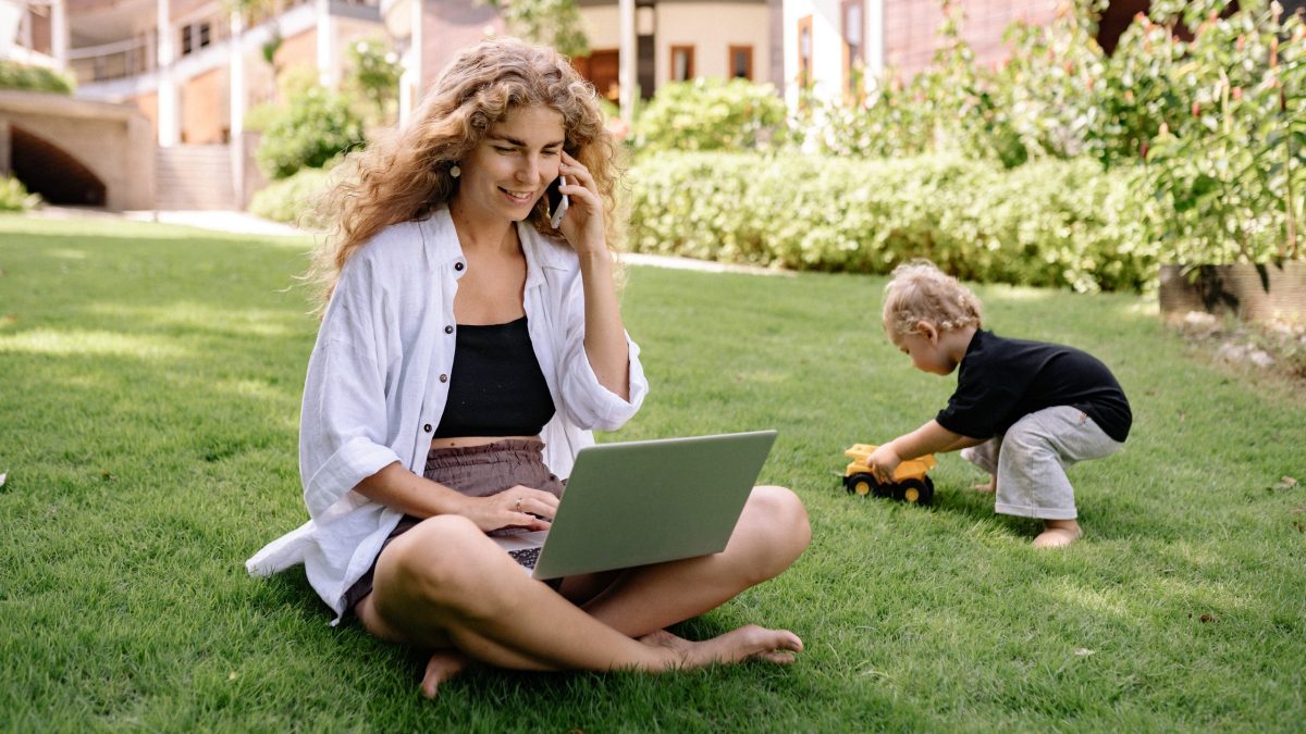 Woman in a yard on laptop