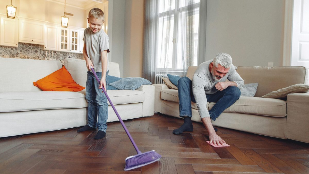 Father and son sweeping the floor