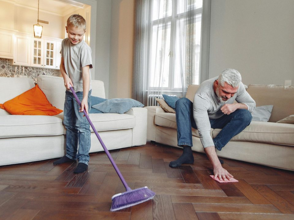 Father and son sweeping the floor