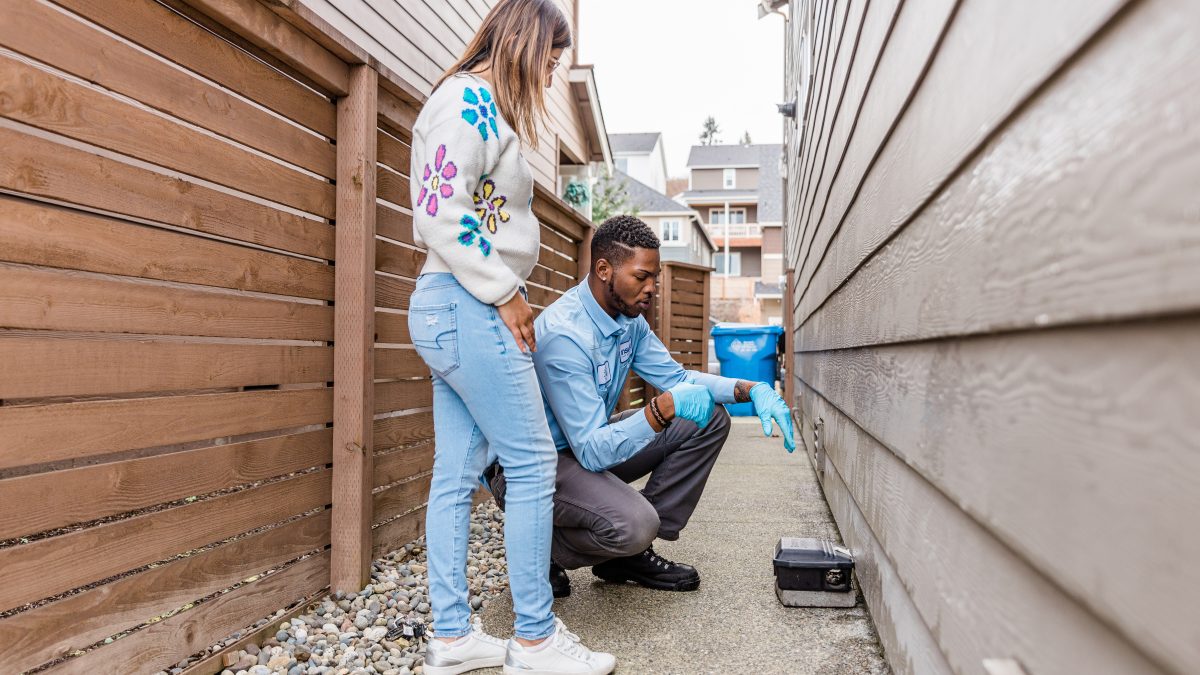 technician talking with client near rodent trap